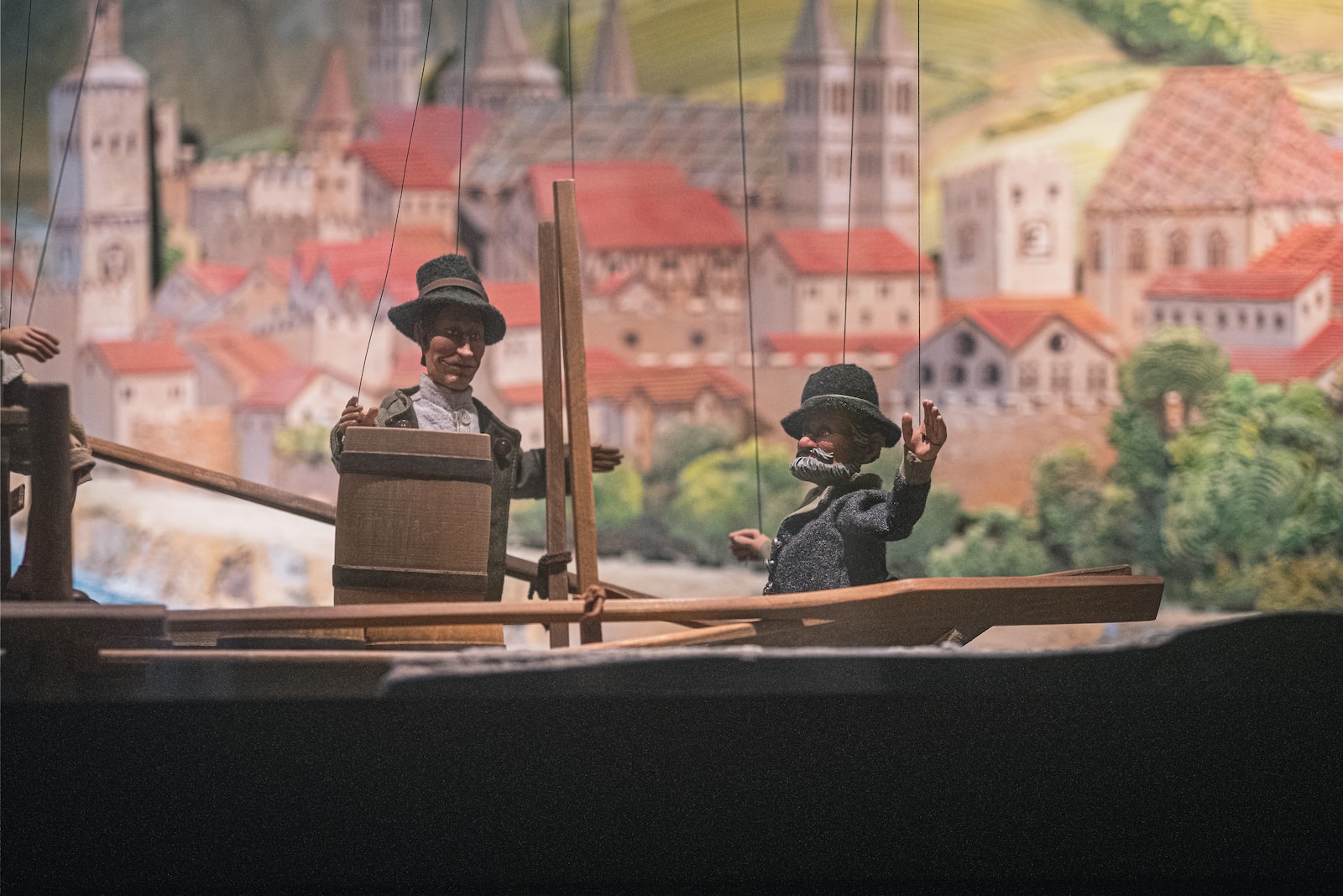 man in black jacket sitting on brown wooden chair