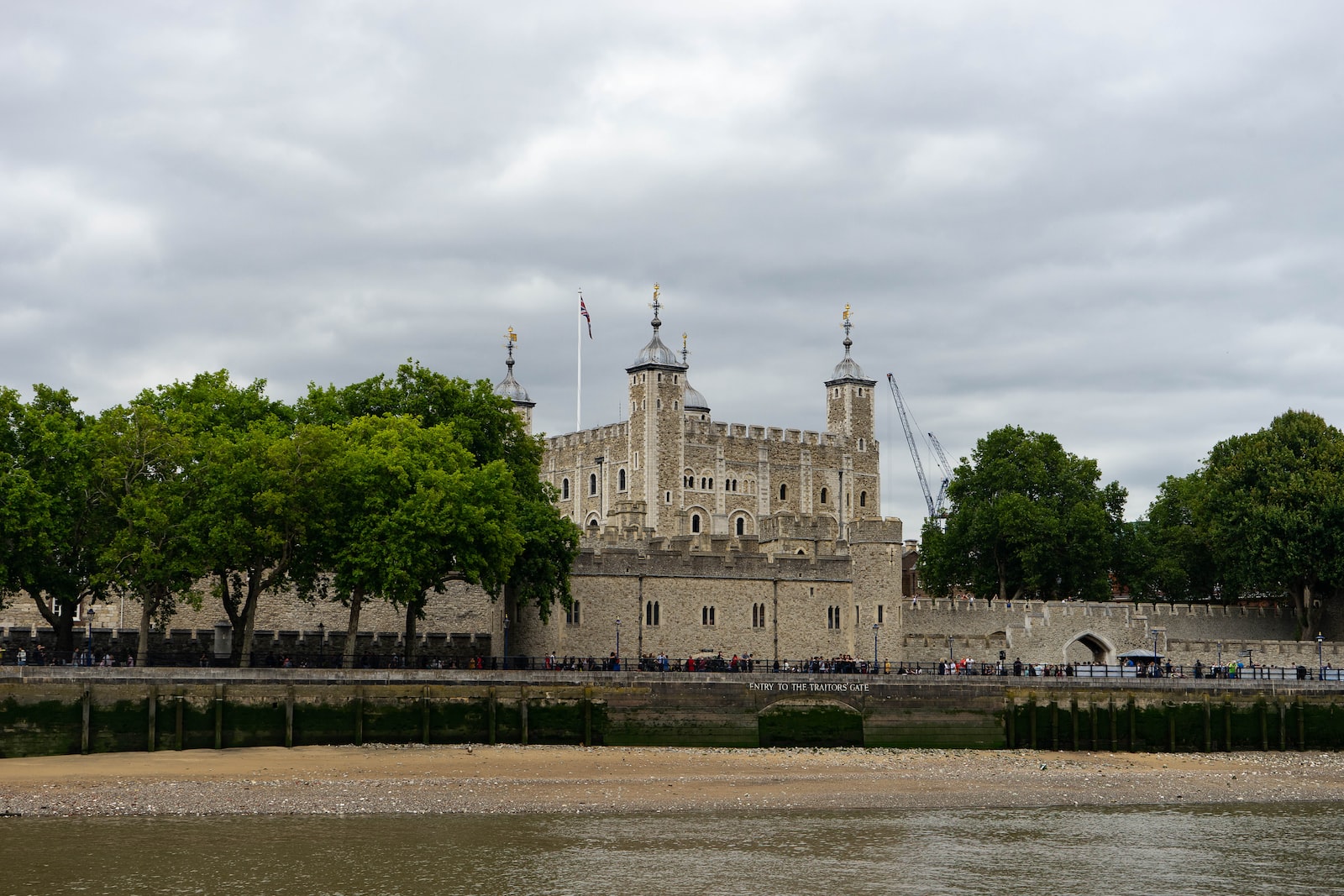 people walking near brown concrete castle under white skies